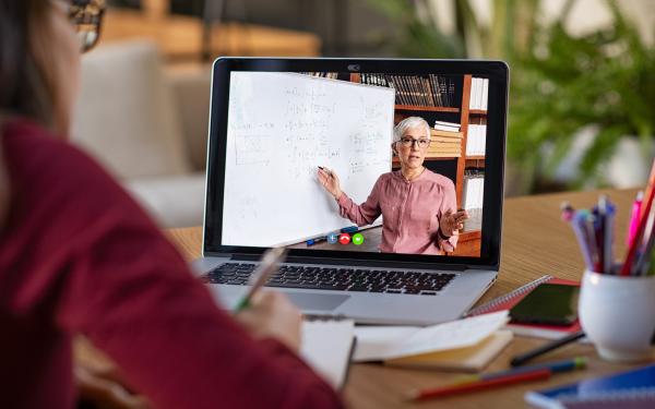 Image of a student watching a Professor on her laptop