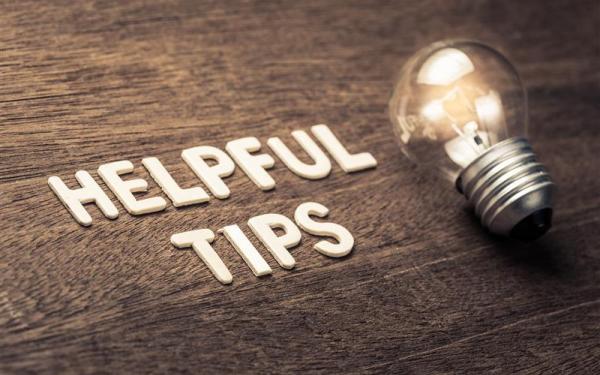 A lightbulb highlights the text "Helpful Tips" against a wooden surface