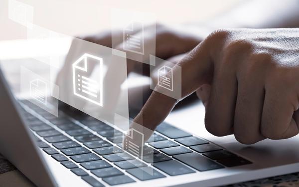 Typing on a laptop with file icons